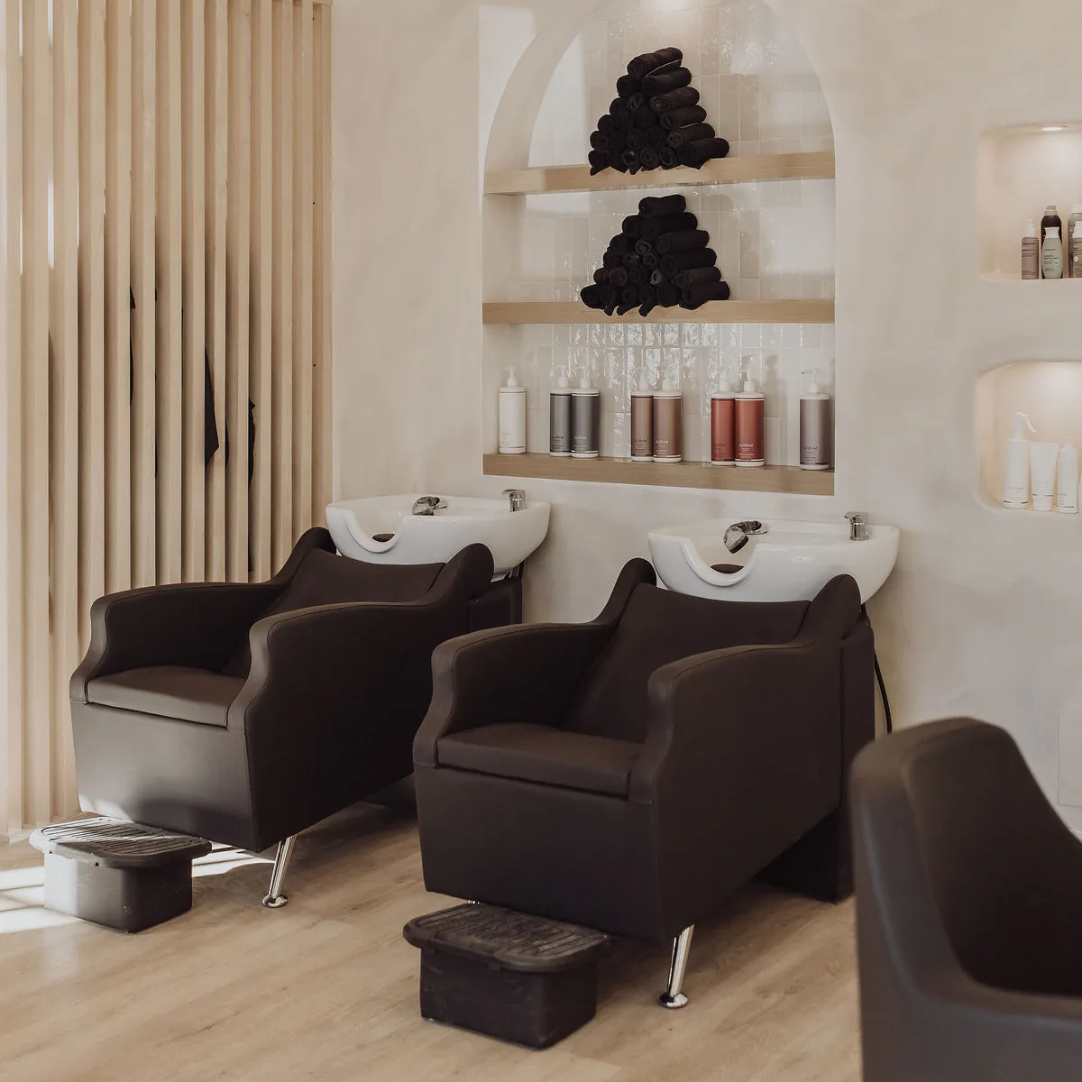 Shampoo chairs under an arched shelf in the Cochrane salon